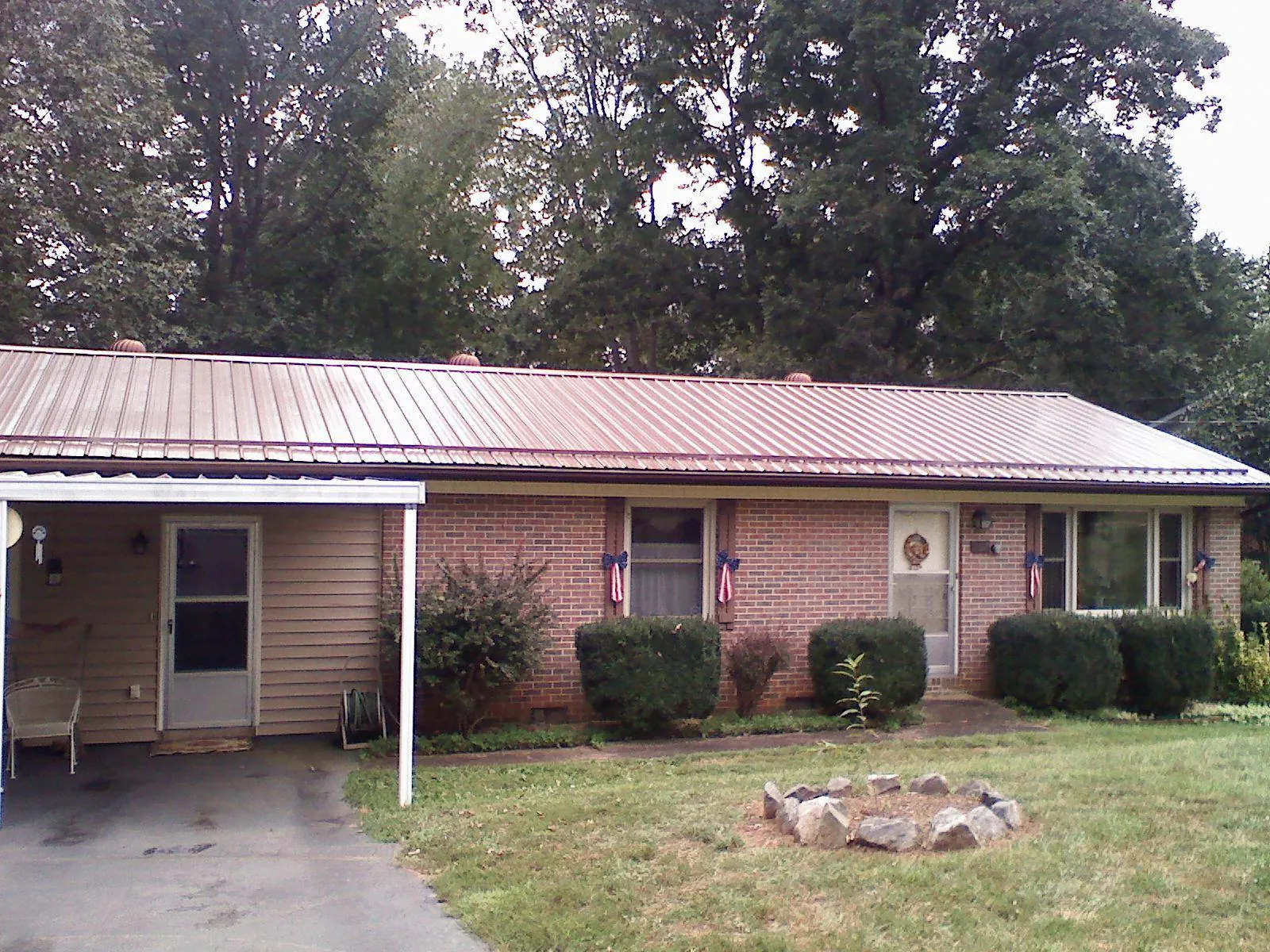 Bronze metal roof and carport on a brick ranch home — Roof Repair work by our crew in Greenwich